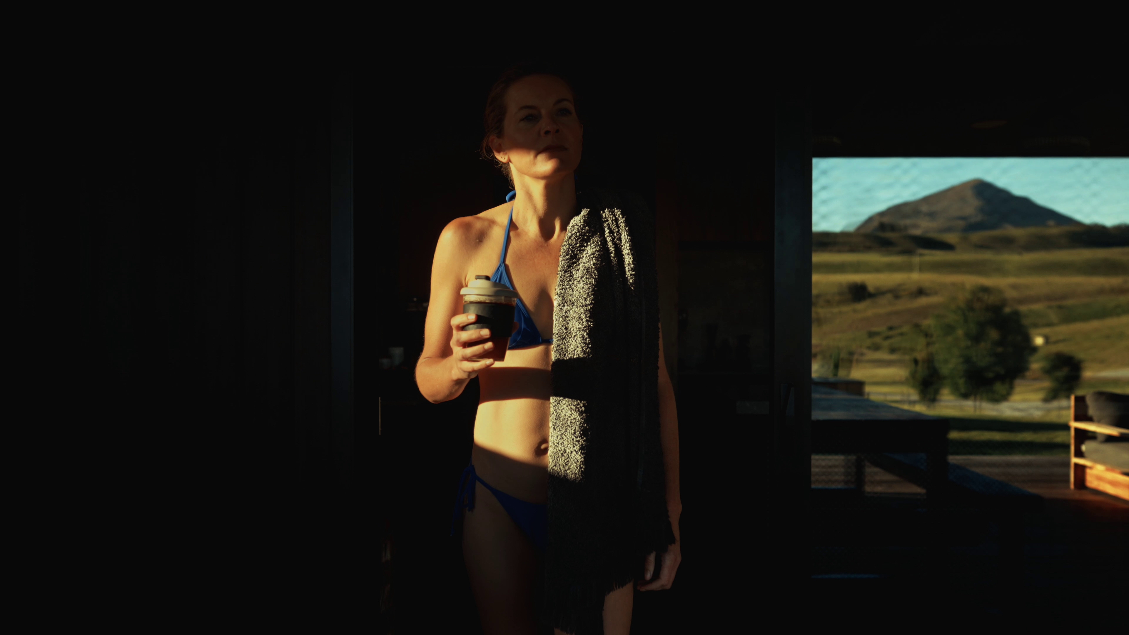 Woman with coffee walking to hot tub