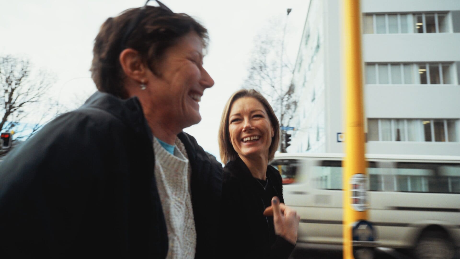 Two sisters laughing in street